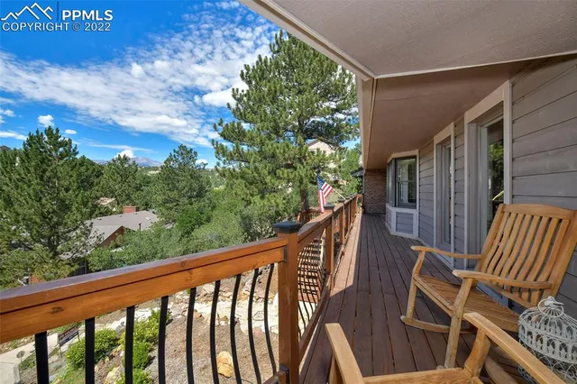 a balcony with wooden floor and outdoor seating