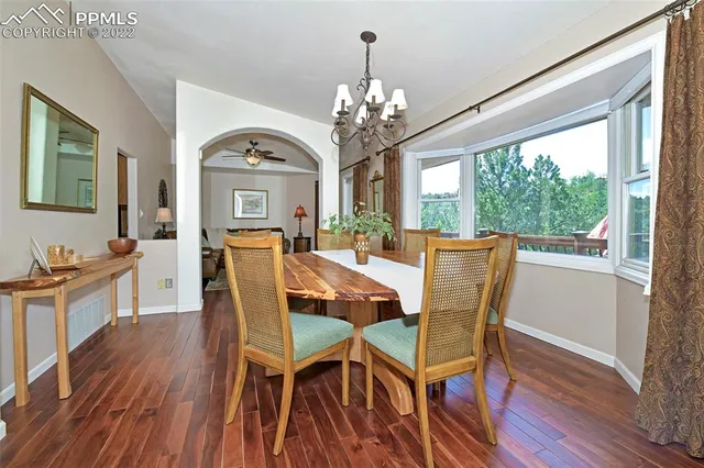 a view of a dining room with furniture a chandelier and wooden floor
