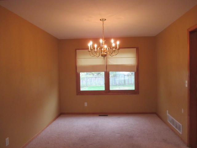 802 Ridge Drive Elburn, IL 60119 - Photo 5 of 14 an empty room with chandelier and windows