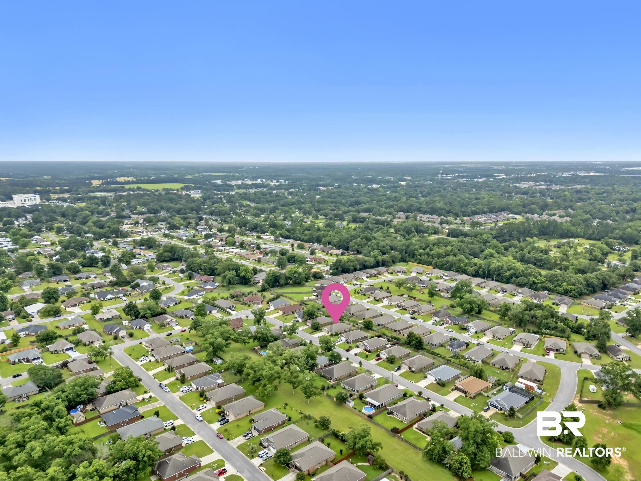 1704 Abbey Loop Foley, AL 36535 - Photo 35 of 38 Aerial perspective of a residential neighborhood featuring numerous single-family homes with pitched roofs, surrounded by mature trees and green spaces