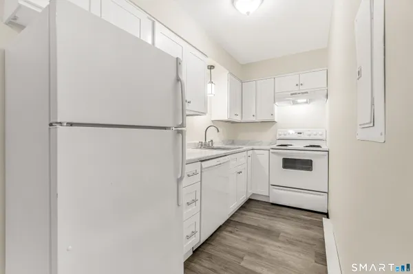 a kitchen with white cabinets and white appliances