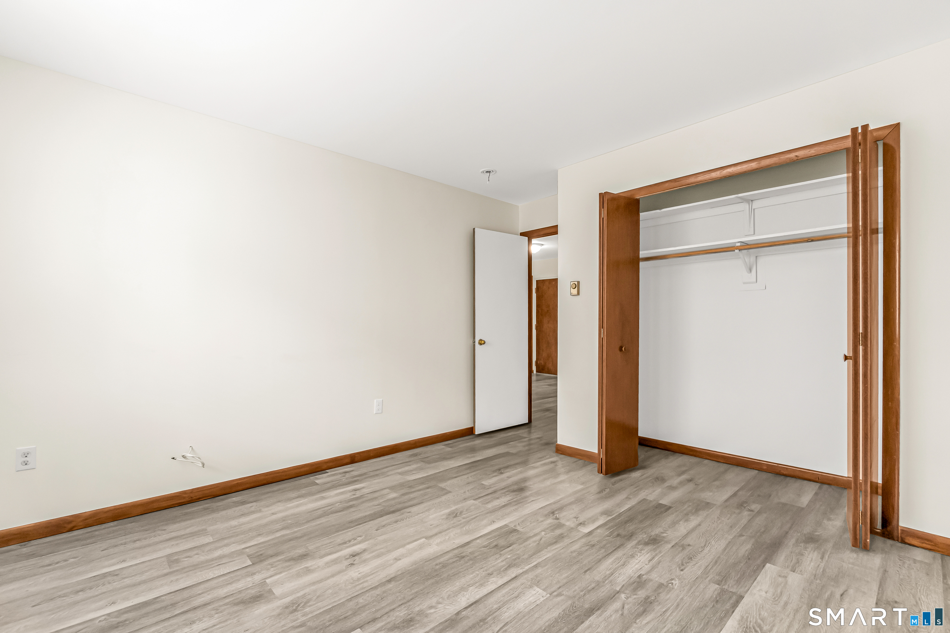 115 Short Beach Road, Unit 103 Stratford, CT 06615 - Photo 6 of 17 a view of an empty room with wooden floor and closet
