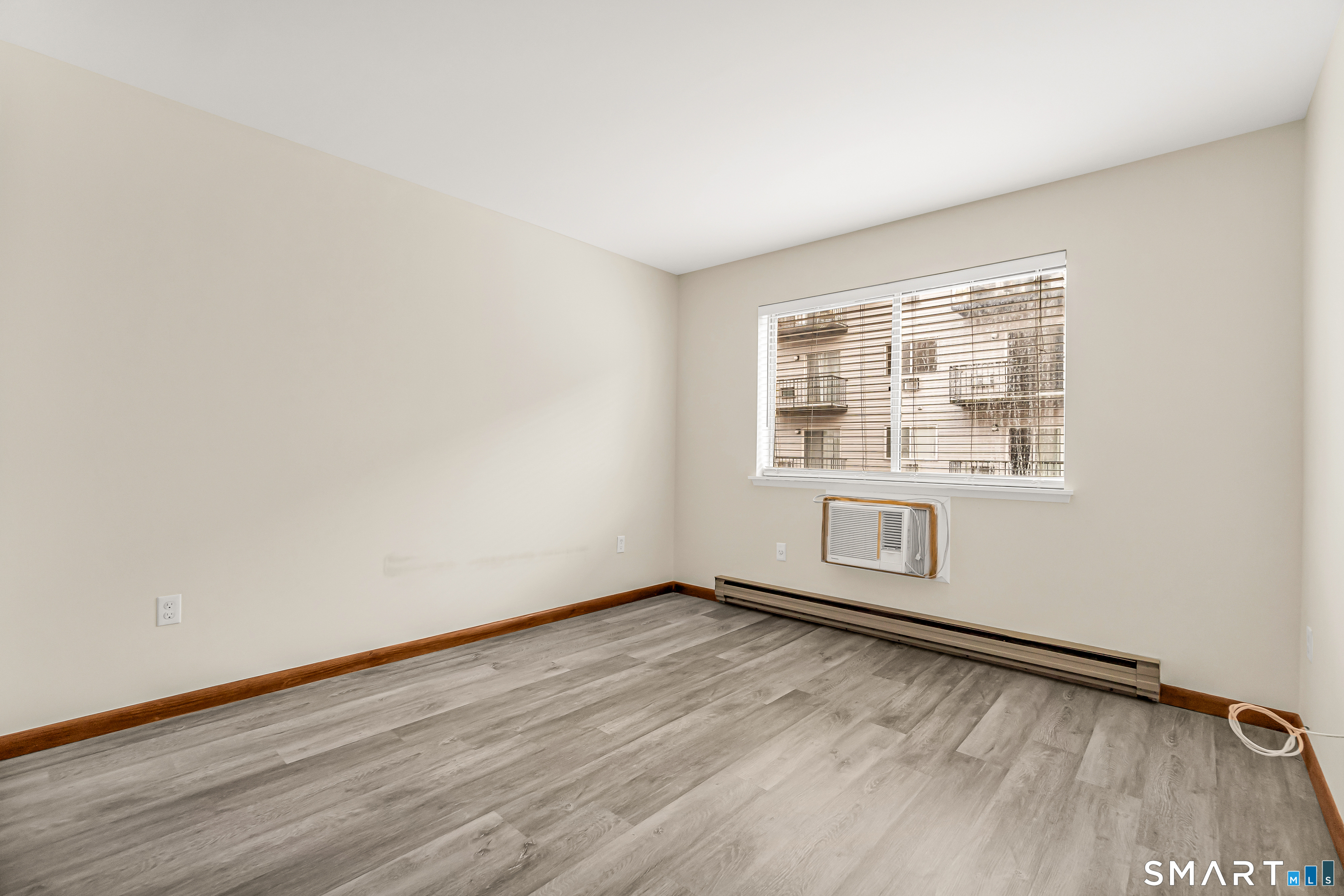 115 Short Beach Road, Unit 103 Stratford, CT 06615 - Photo 8 of 17 an empty room with wooden floor and windows