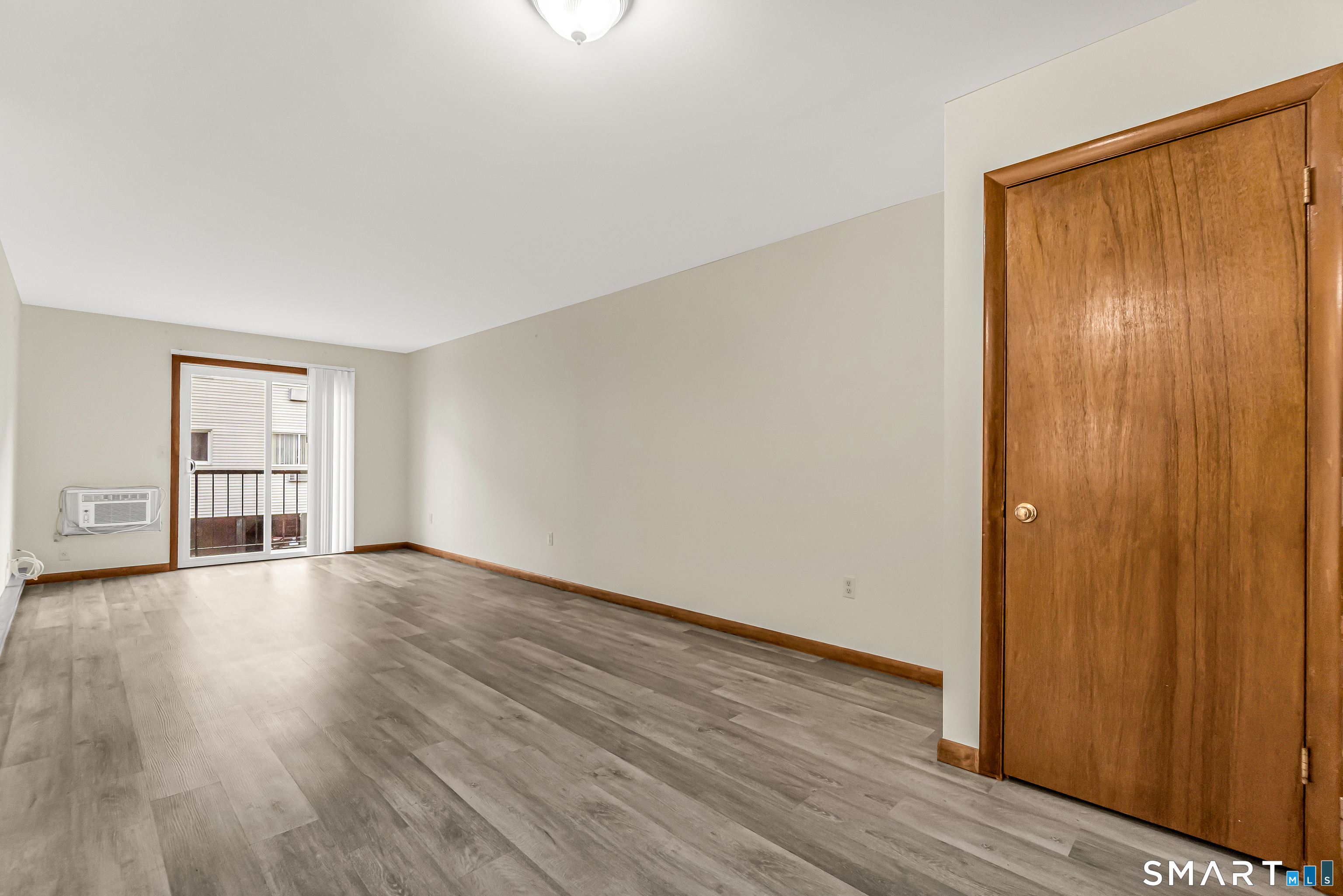 115 Short Beach Road, Unit 103 Stratford, CT 06615 - Photo 10 of 17 an empty room with wooden floor and windows