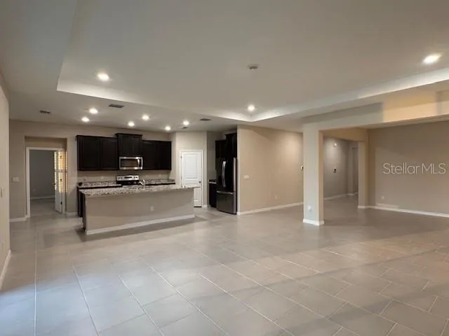 a view of large kitchen with a sink and refrigerator