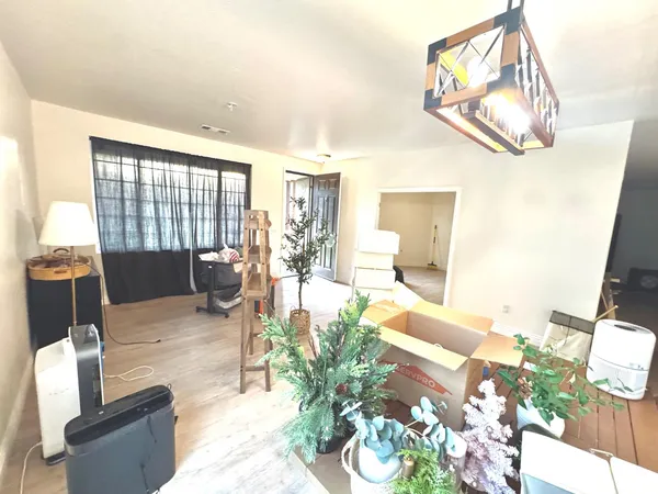 a living room with furniture a dining table with rug floor and a large window