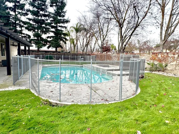 a view of a swimming pool with a fountain in the background