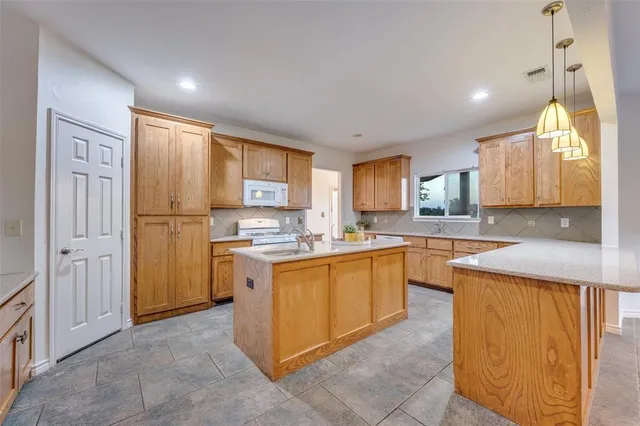 a kitchen with stainless steel appliances granite countertop a refrigerator and a stove top oven