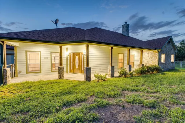 a view of yellow house with a big yard