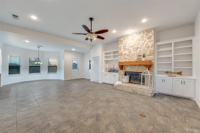 a view of an empty room with a fireplace and a window