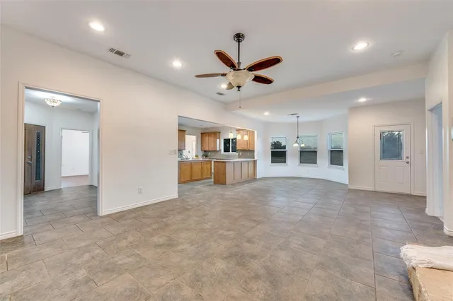 an empty room with chandelier and windows