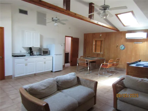 a living room with furniture and kitchen view