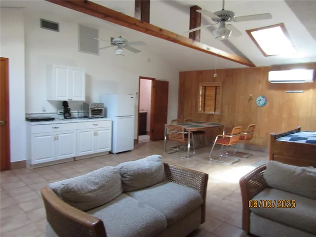 a living room with furniture and kitchen view