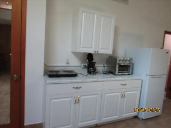 a kitchen with white cabinets and white appliances