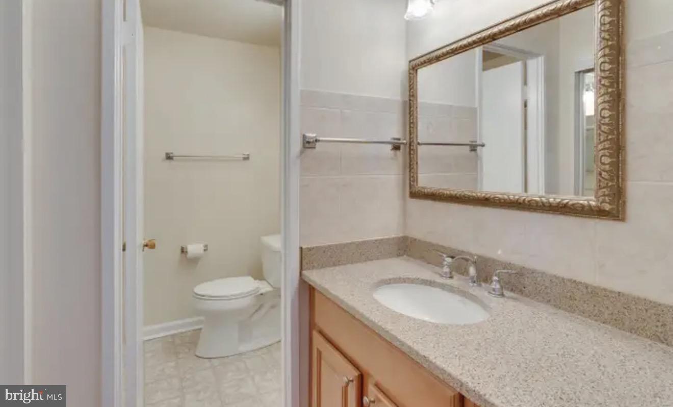 1707 Tyvale Court Vienna, VA 22182 - Photo 12 of 28 a bathroom with a granite countertop sink toilet and shower