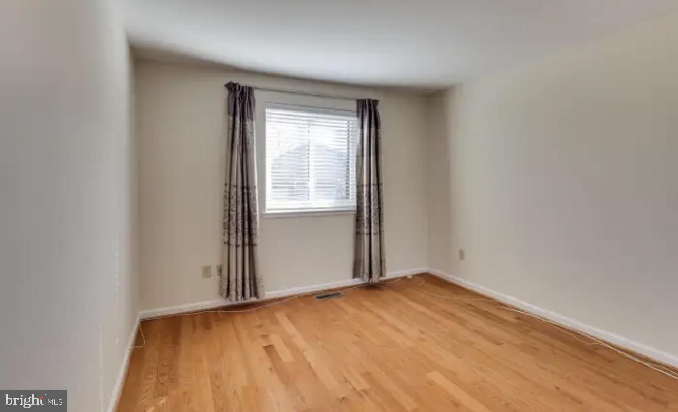 1707 Tyvale Court Vienna, VA 22182 - Photo 13 of 28 an empty room with wooden floor and windows