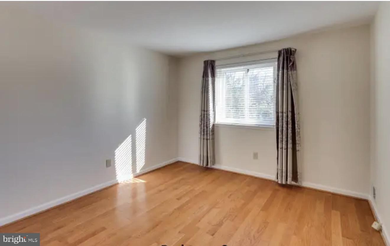 1707 Tyvale Court Vienna, VA 22182 - Photo 15 of 28 an empty room with wooden floor and windows