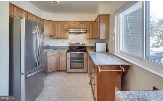 a kitchen with a refrigerator stove and cabinets
