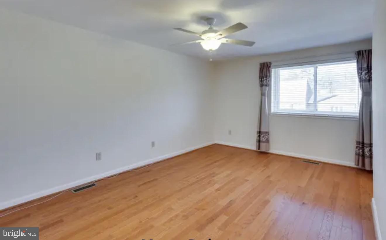 1707 Tyvale Court Vienna, VA 22182 - Photo 10 of 28 a view of an empty room with a window and wooden floor