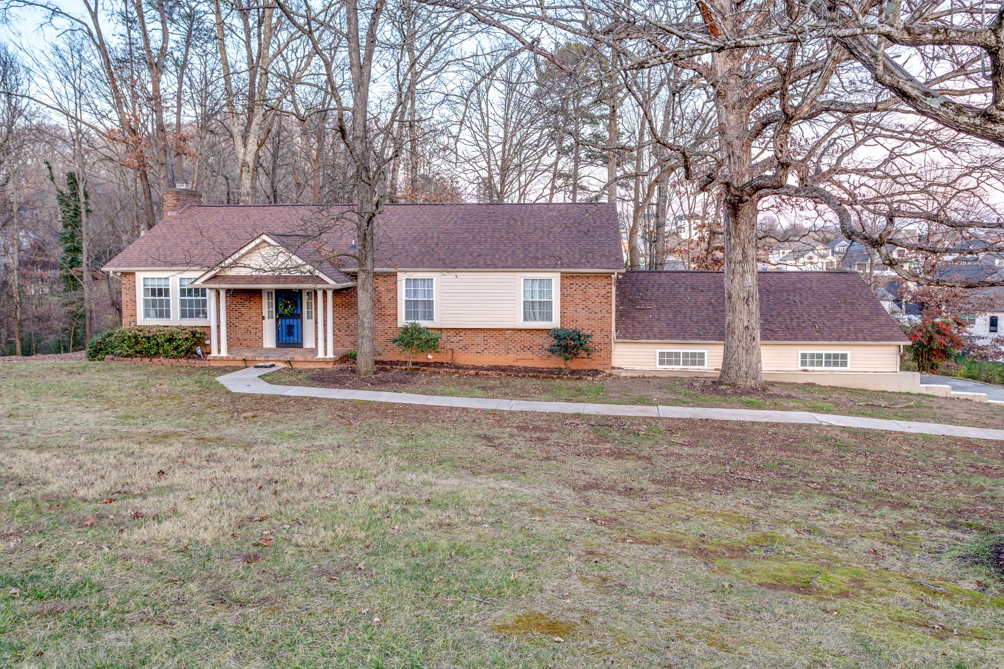 a front view of house with yard and trees around