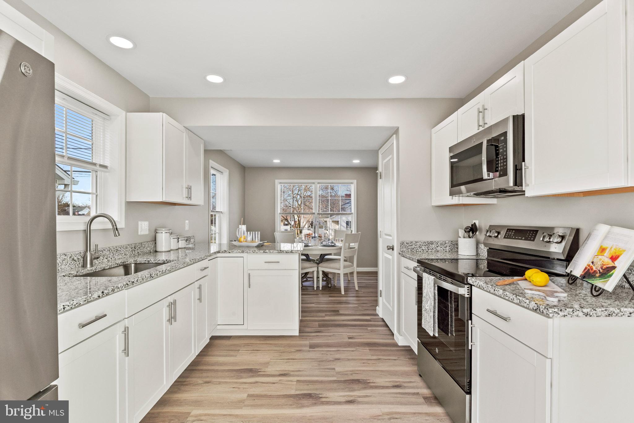 41573 Church Street Leonardtown, MD 20650 - Photo 11 of 27 a large white kitchen with stainless steel appliances granite countertop lots of counter space and wooden floors