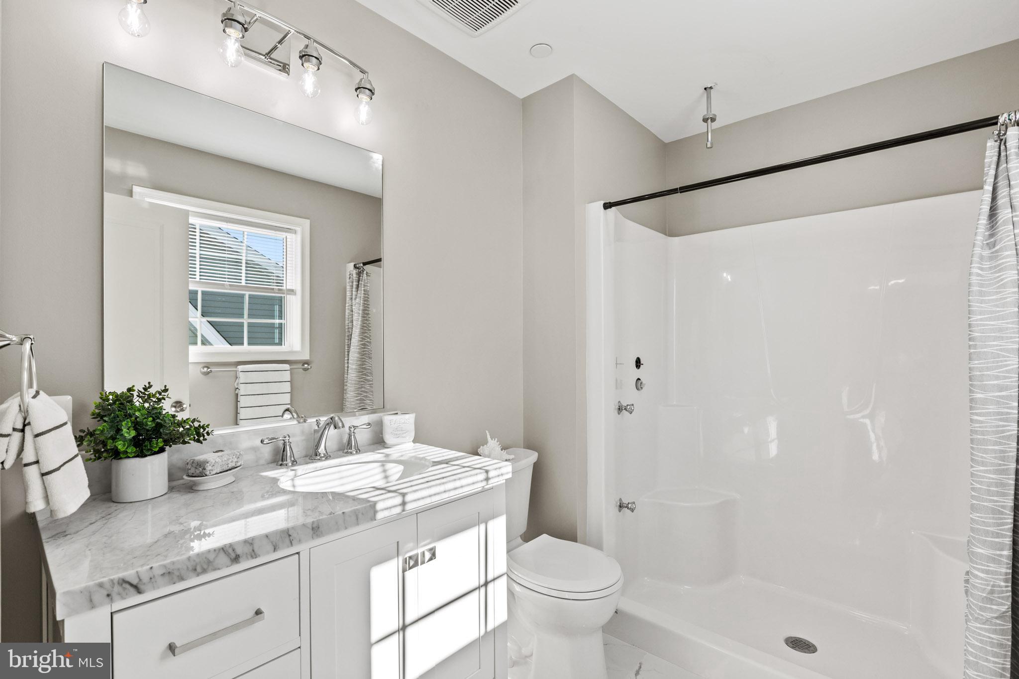 41573 Church Street Leonardtown, MD 20650 - Photo 26 of 27 a bathroom with a granite countertop sink a toilet and shower