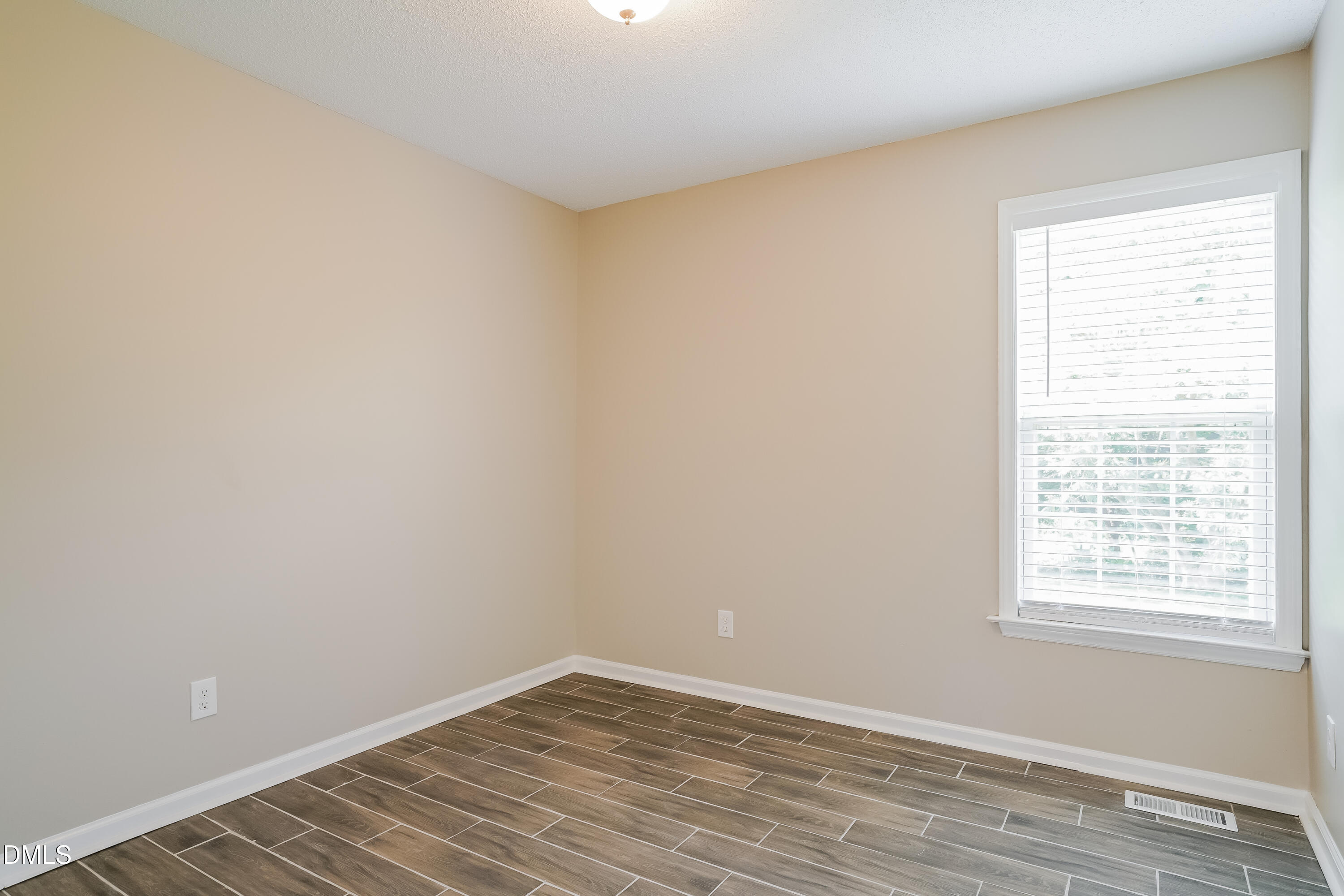 110 Impressive Lane Clayton, NC 27520 - Photo 11 of 16 wooden floor in an empty room with a window