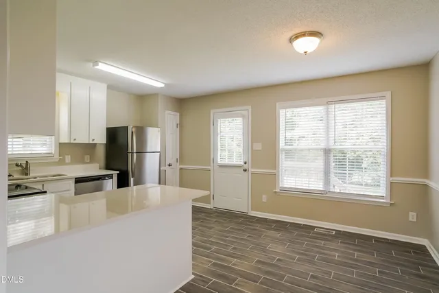 a kitchen with stainless steel appliances a refrigerator and a stove top oven