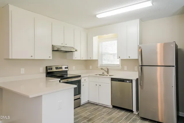 a kitchen with stainless steel appliances a refrigerator sink and cabinets