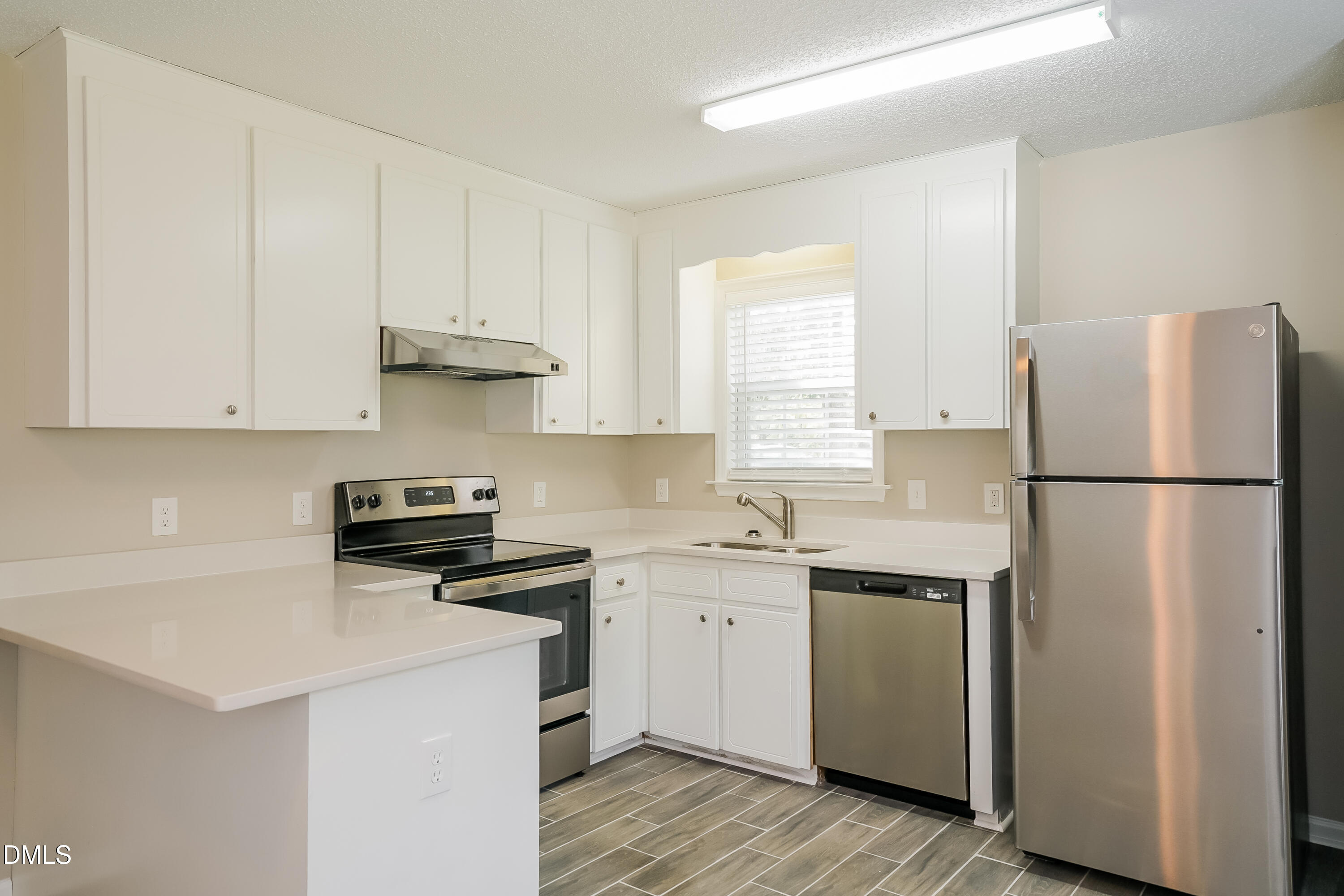 110 Impressive Lane Clayton, NC 27520 - Photo 6 of 16 a kitchen with stainless steel appliances a refrigerator sink and cabinets