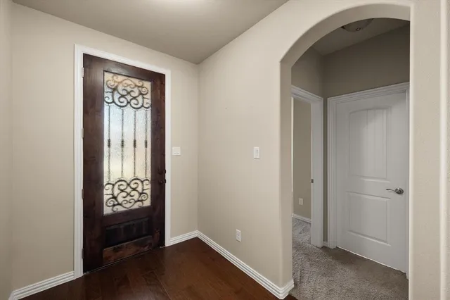 an empty room with wooden floor closet and windows