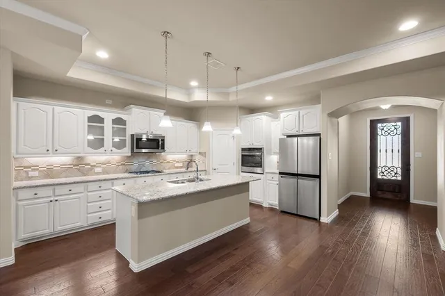 a kitchen with refrigerator a sink and wooden floor