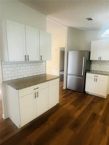 a kitchen with a sink and wooden floor