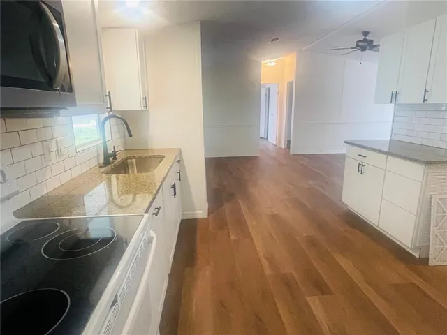 a kitchen with stainless steel appliances granite countertop a sink a stove and microwave