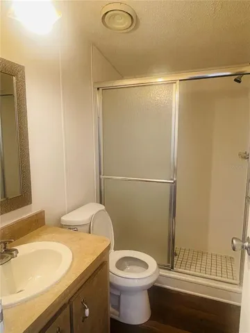 a view of an empty room with wooden floor and closet