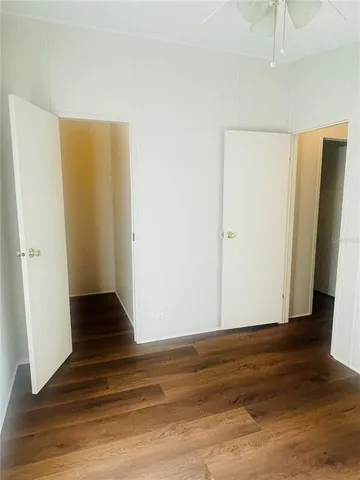 an empty room with a window and a ceiling fan