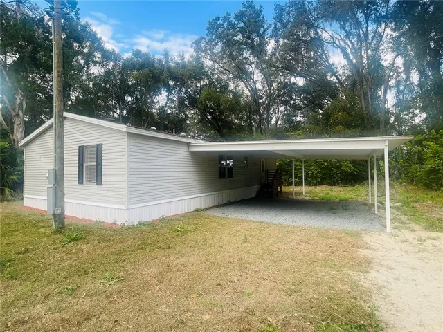a view of a house with backyard and trees