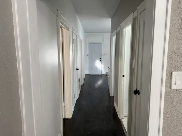 a view of a hallway with wooden floor