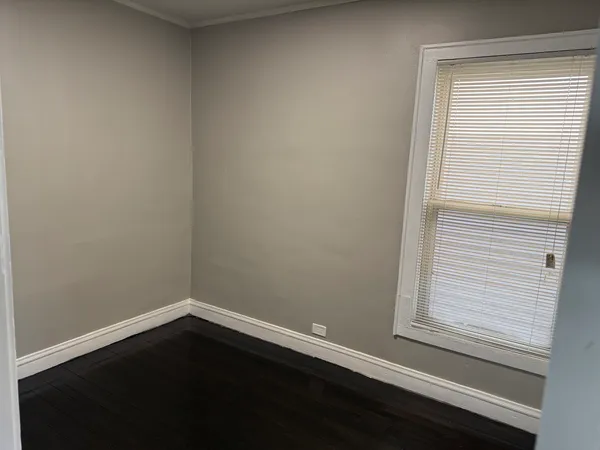 a view of a small space with wooden floor and a window