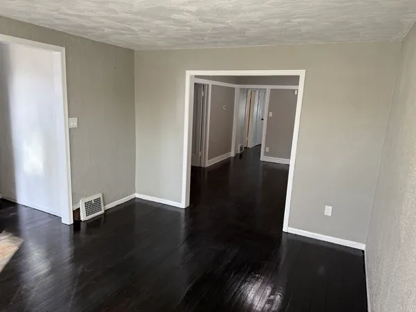 an empty room with wooden floor and closet