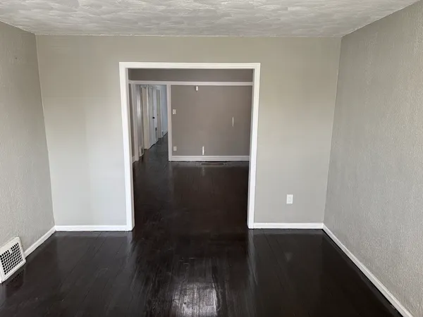 a view of empty room with wooden floor