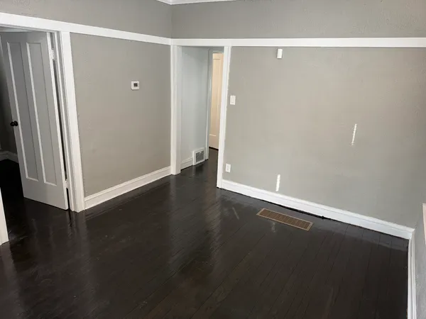 an empty room with wooden floor and closet