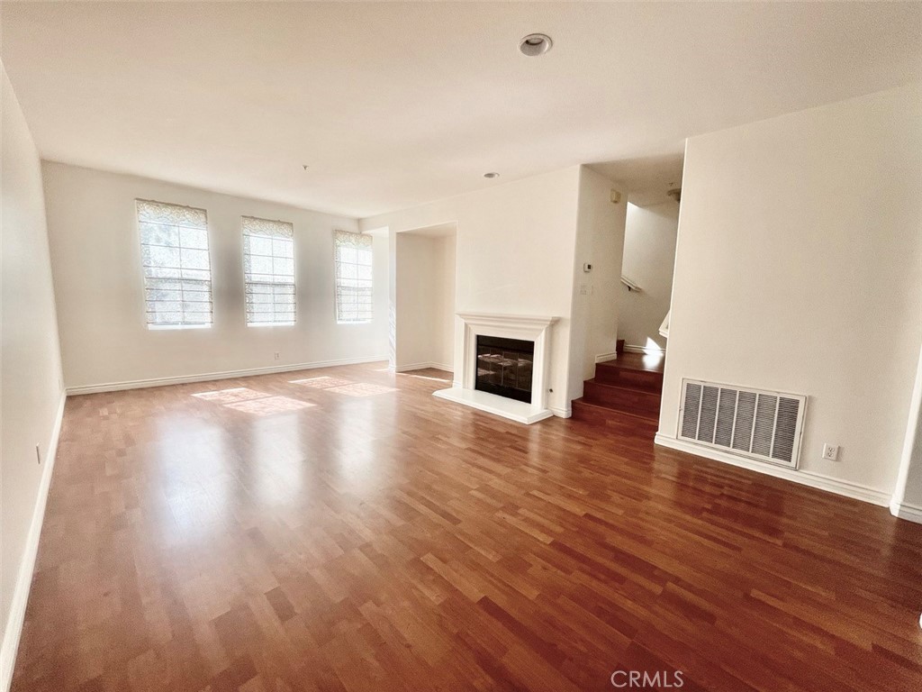 65 Passage Irvine, CA 92603 - Photo 12 of 28 an empty room with wooden floor and fireplace