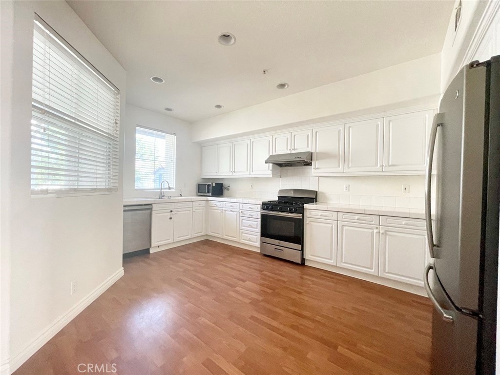 65 Passage Irvine, CA 92603 - Photo 14 of 28 a kitchen with white cabinets and white appliances