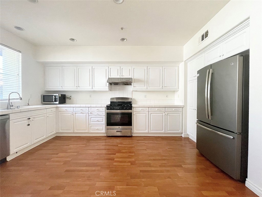 65 Passage Irvine, CA 92603 - Photo 15 of 28 a kitchen with granite countertop a refrigerator sink and cabinets