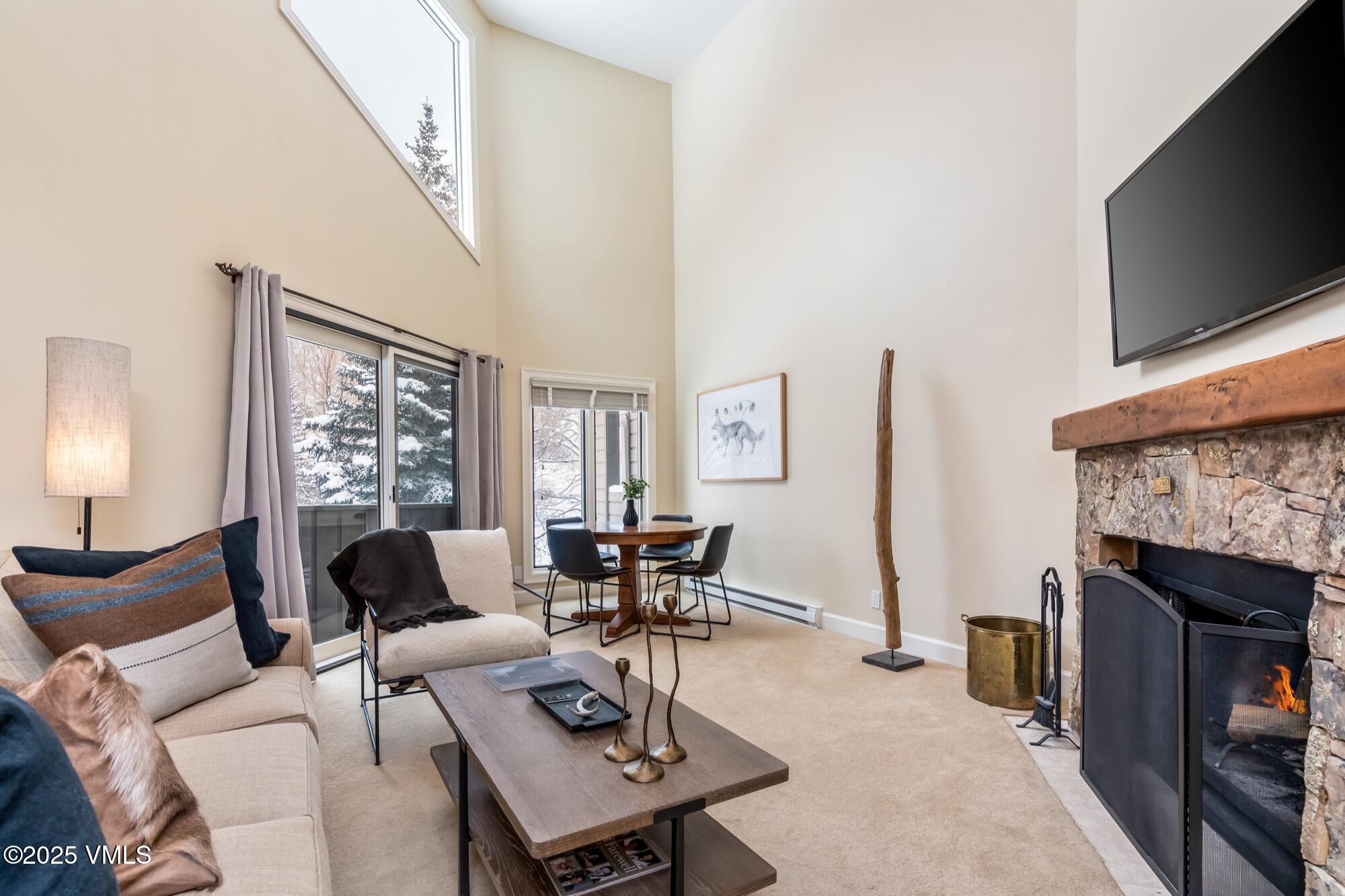 945 Red Sandstone Road, Unit A5 Vail, CO 81657 - Photo 2 of 38 a living room with furniture a fireplace and a flat screen tv