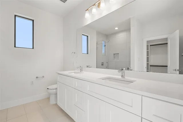 a bathroom with a granite countertop sink mirror and toilet