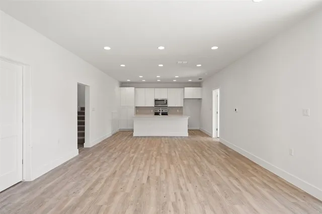 a view of a kitchen with a sink and dishwasher a refrigerator with wooden floor