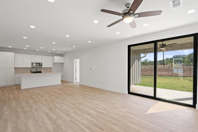 a view of kitchen with refrigerator and a ceiling fan