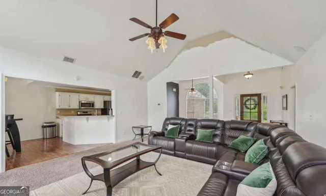 a living room with furniture and kitchen view